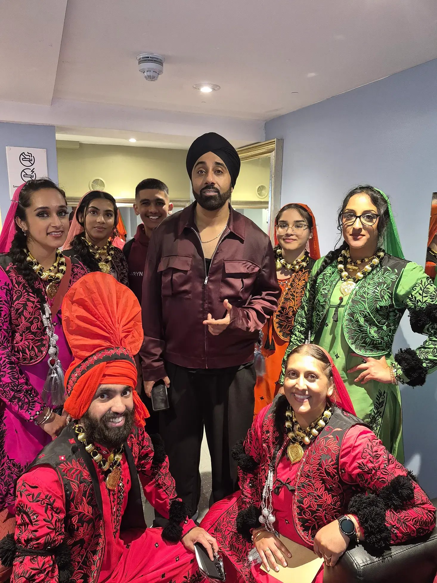 The Jodi Dancers team in full bhangra costume backstage with Jassi Sidhu