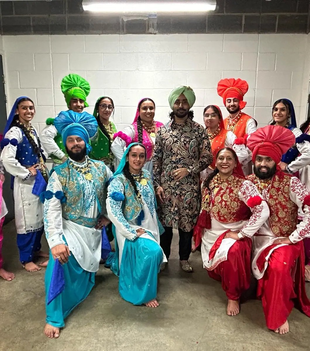 The Jodi Dancers team in full bhangra costume backstage with Satinder Sartaaj