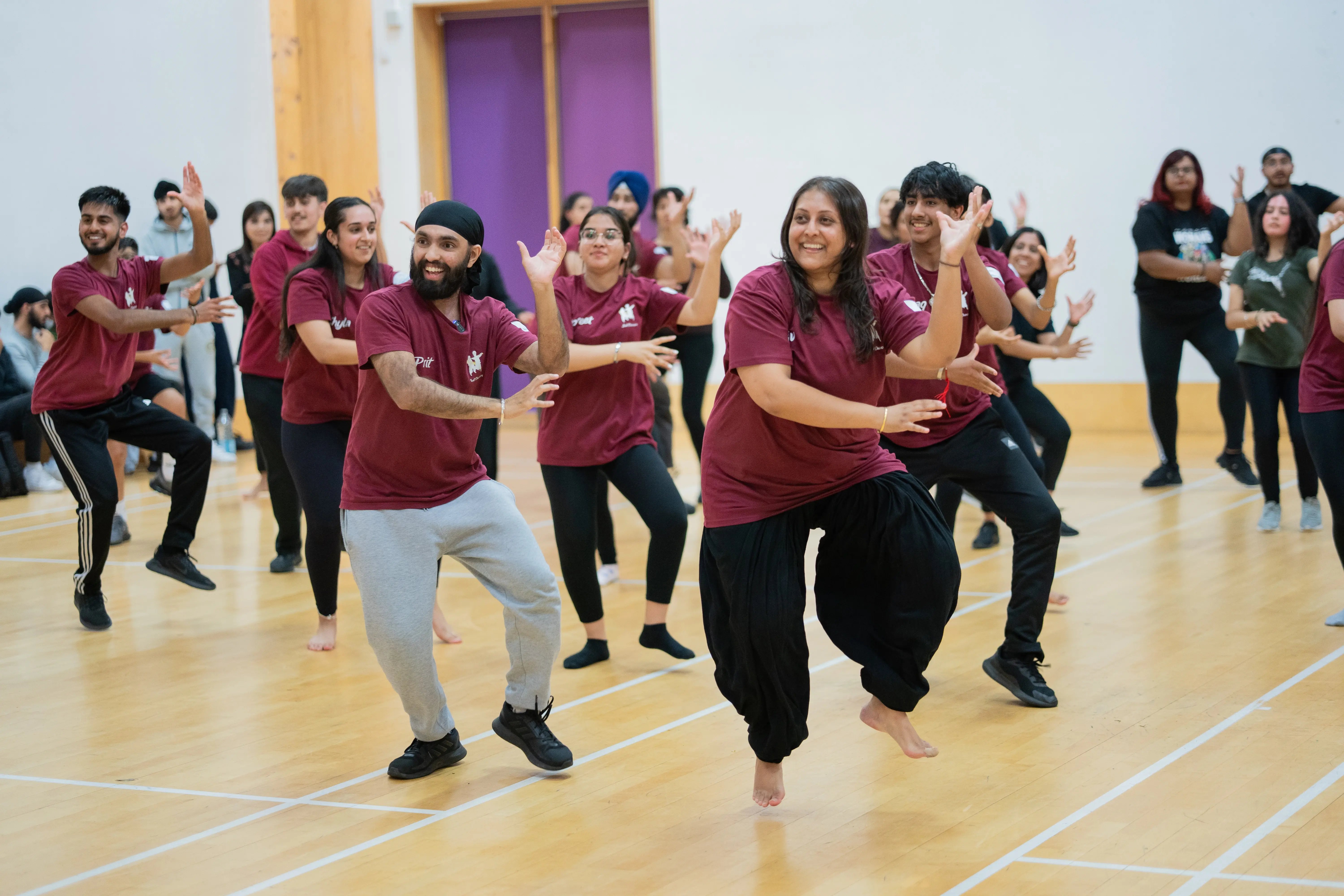 Pritpal and Ravneet leading a packed School of Bhangra class in a sports hall