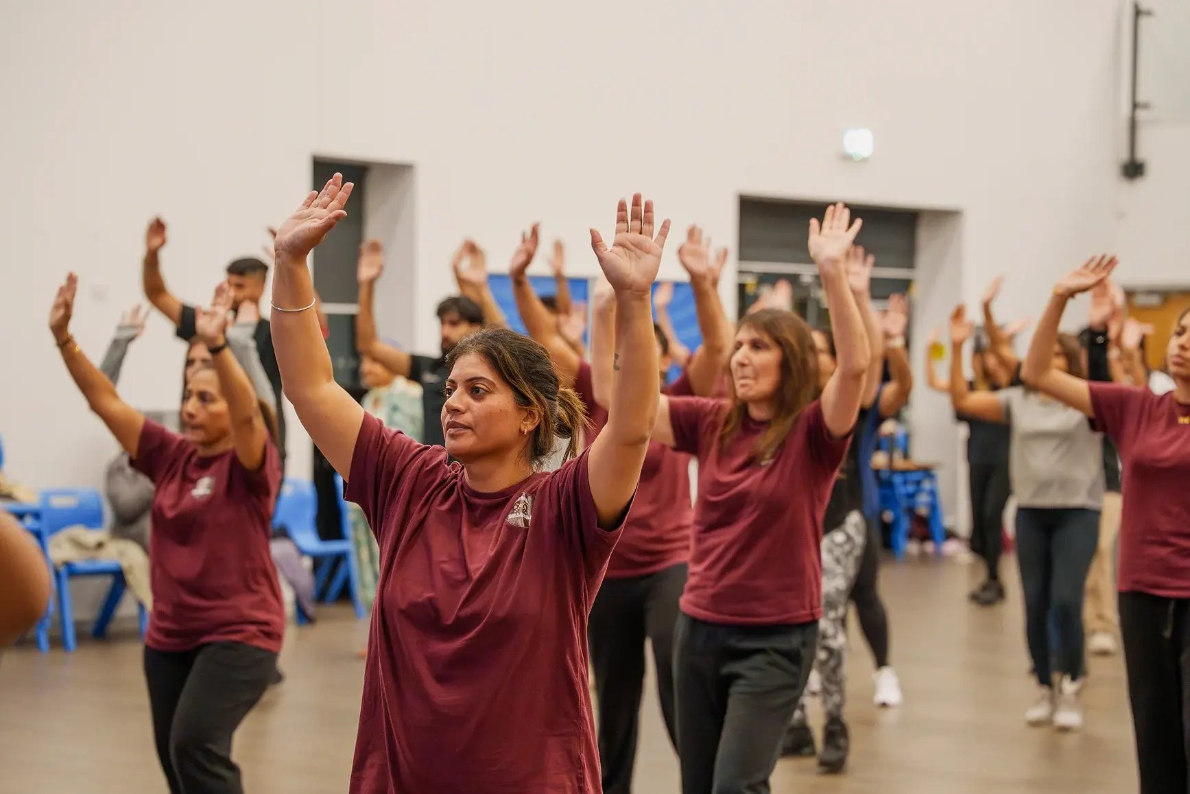 group-practising-bhangra-routine-with-raised-arms