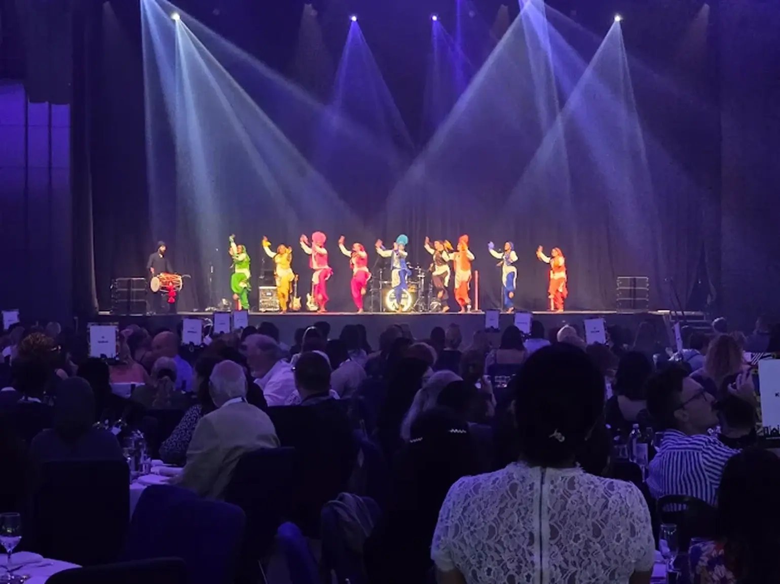 bhangra-dancers-performing-on-stage-for-seated-audience
