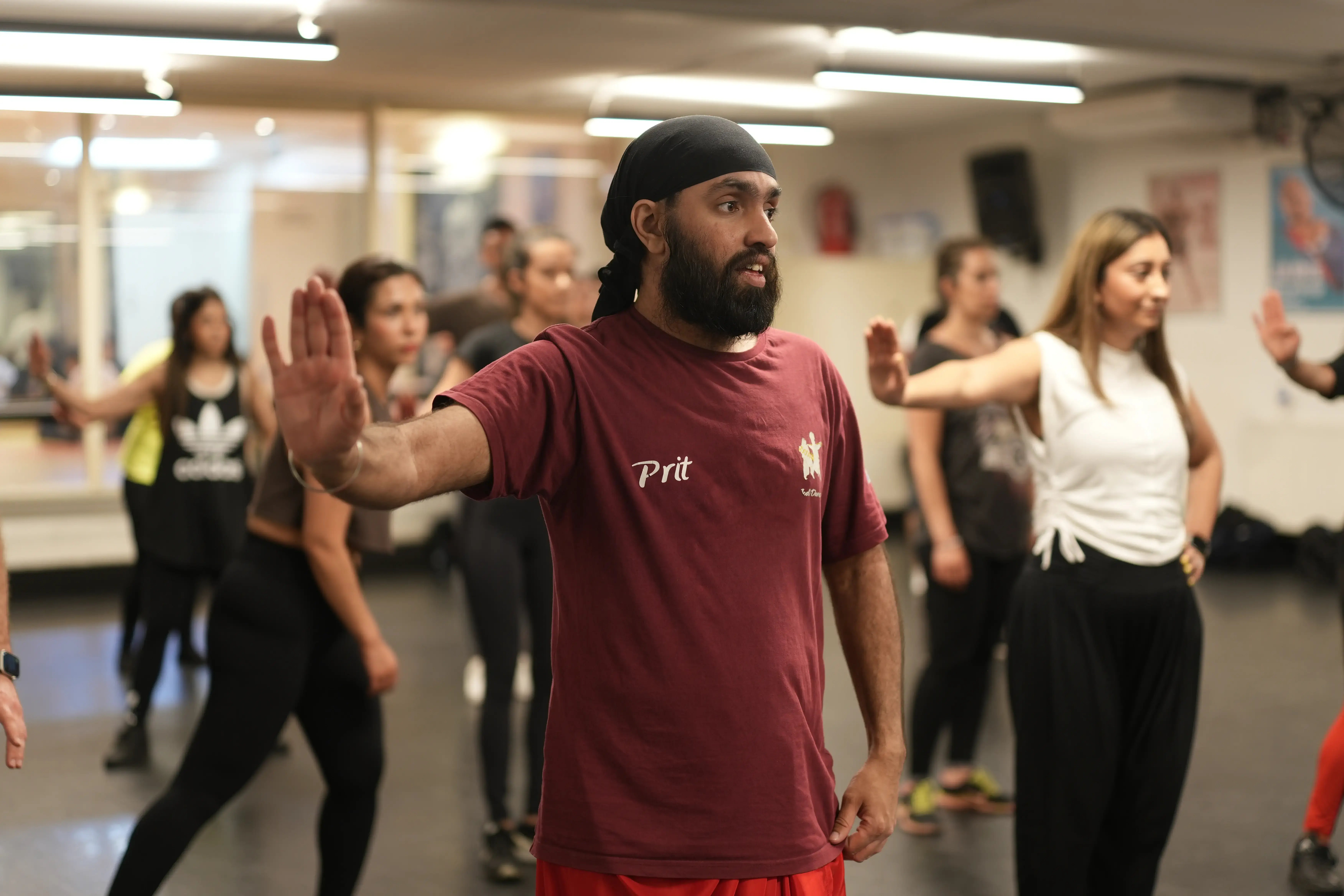 Dance instructor leading a group through a movement exercise in a studio workshop.