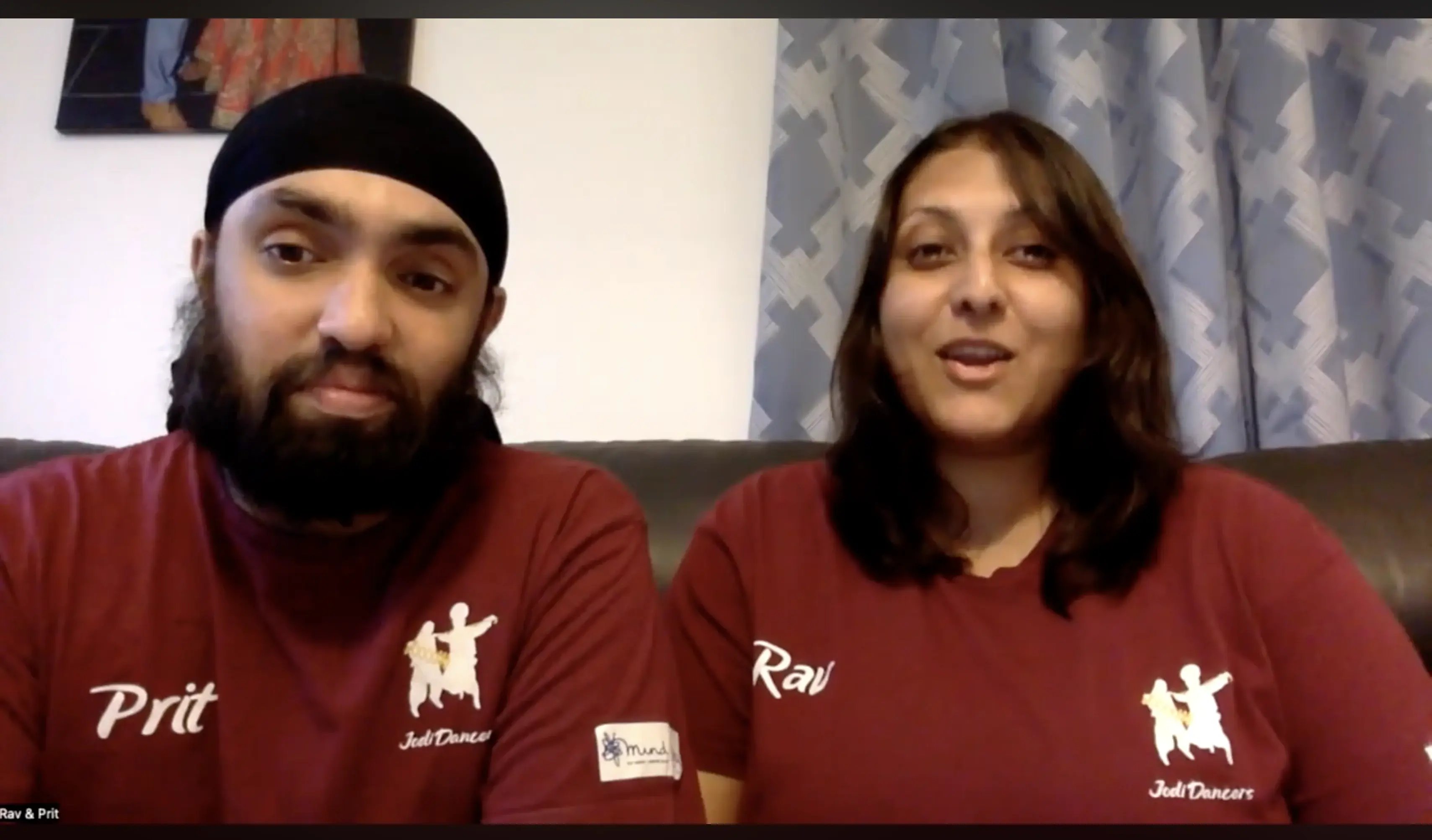 Two Jodi Dancers team members wearing matching maroon shirts speaking together during a video call.